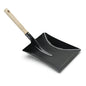 The Nölle Profi Brush dustpan lacquered metal with wooden handle from Nölle Profi Brush Bürsten- & Pinseltechnik e.K. is a black metal dustpan with a wide, flat scoop and a light wooden handle, standing on a white background.
