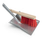 A Nölle Profi Brush dustpan set (galvanized metal dustpan with 28 cm hand brush, red bristles) by the brand Nölle Profi Brush Bürsten- & Pinseltechnik e.K., hand brush diagonally on the dustpan, against a white background.