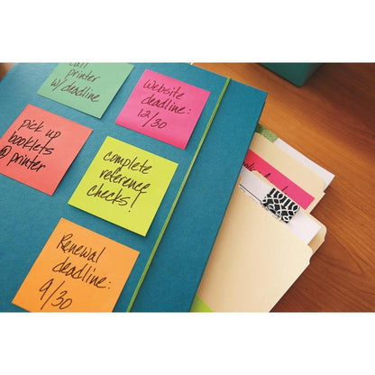 A blue folder with colorful 3M Deutschland GmbH Post-it® Notes Cube, Ultra Colors (76x76 mm, 450 sheets/block, PEFC-certified), listing tasks, lies next to manila folders and a notepad on a wooden table.