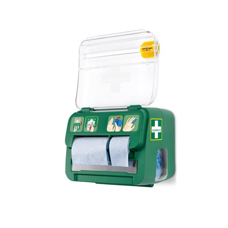 The green, wall-mounted Cederroth Soft Foam Bandage 2-in-1 Dispenser from Orkla Wound Care AB holds six bandages, features a transparent lid with a cross symbol, blue paper rolls, illustrated instructions, and a yellow emergency wound care tool on top.