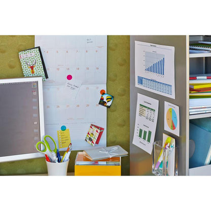 A workspace with a calendar, monitor, and office supplies, where charts and diagrams are pinned to the wall with 3M Deutschland GmbH Scotch-FIX™ Removable Adhesive Pads 301008C36-P (11 mm x 15 mm, 36 pieces/pack) near shelves with binders and notebooks.