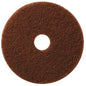 The brown, round TASKI Americo Pad Brown - Aggressive floor cleaning pad from Diversey Deutschland GmbH & Co. OHG has a textured surface, a central hole, and is depicted from above on a white background.