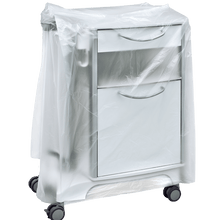 A white medical bedside table on wheels is partially covered with a transparent DEISS 59867 bedside table cover (600+500x1000x0.01 mm) from EMIL DEISS KG, which conceals the drawers and handles. The background is simple and neutral.