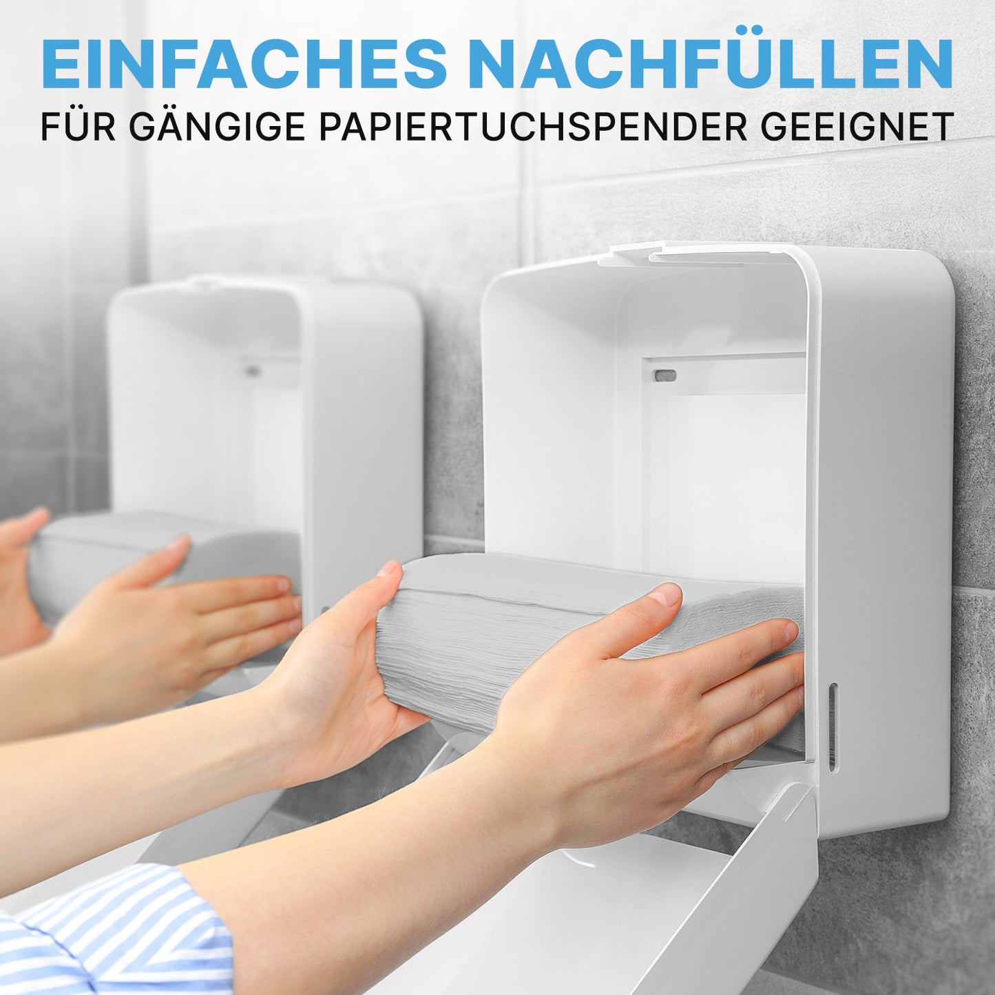 A person refills a white dispenser with ARNOMED PAPER TOWELS 25 x 23 cm | V-FOLD from ARNOWA GmbH. Another identical dispenser stands next to it. The German text describes the easy refilling and compatibility with common washroom dispensers.
