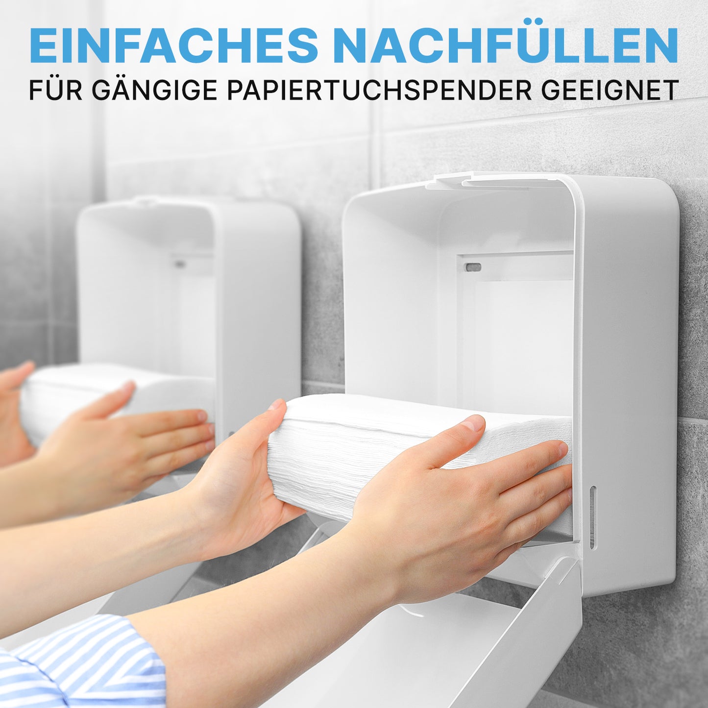 A person refills a white dispenser with ARNOMED PAPER TOWELS 25 x 23 cm | V-FOLD from ARNOWA GmbH in a modern washroom. The German text states that they are easy to refill and fit standard dispensers.