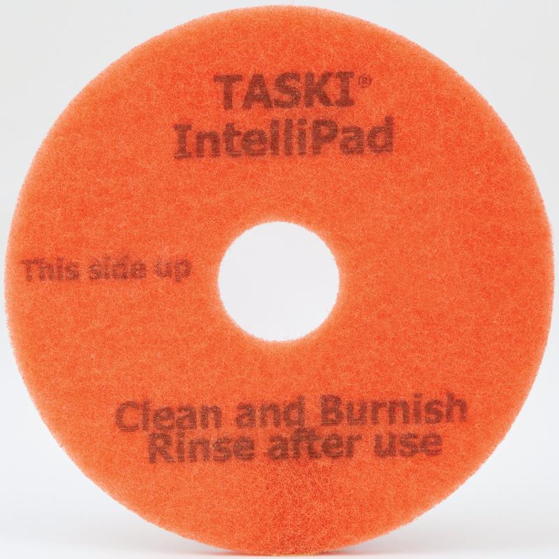 An orange round TASKI Intellipad Combined Cleaning and Polishing Pad for maintenance cleaning from Diversey Deutschland GmbH & Co. OHG, with a central hole and text: "TASKI Intellipad", "This side up", "Clean and Polish Rinse after use.