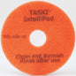 A round, orange "TASKI Intellipad Combined Cleaning and Polishing Pad for Maintenance Cleaning" from Diversey Deutschland GmbH & Co. OHG, with "This side up" text, center hole, textured surface - ideal for cleaning and polishing.