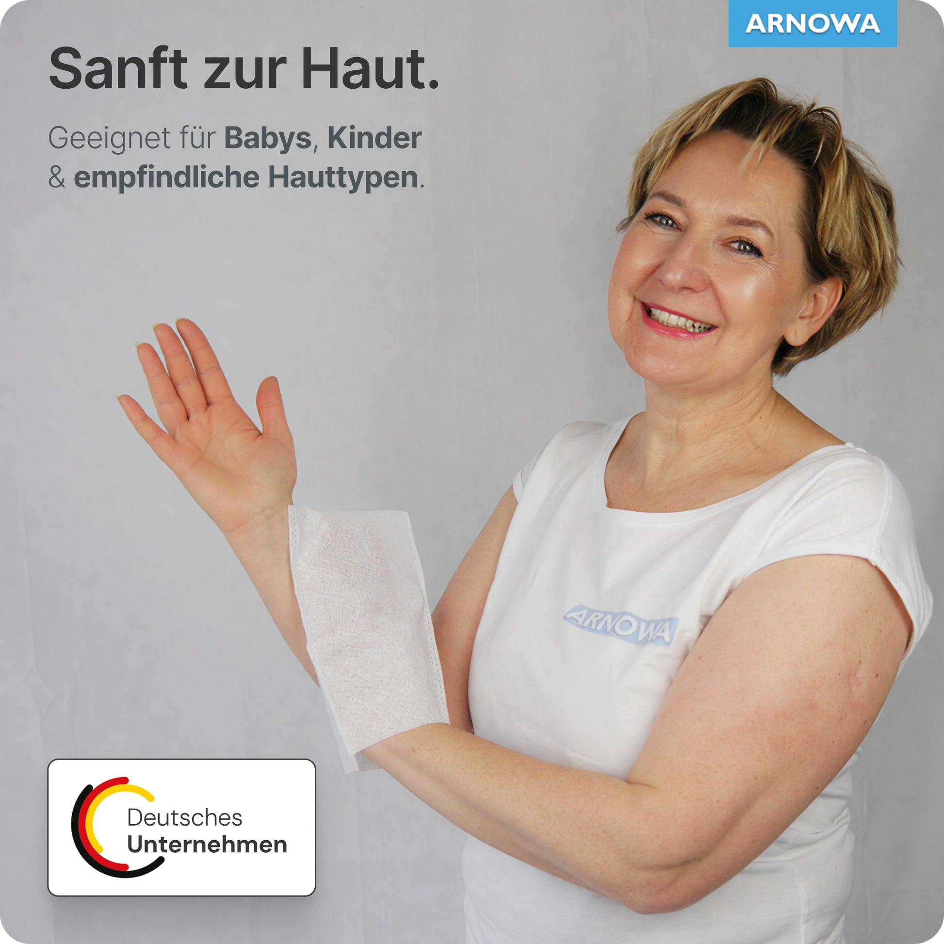 A woman in a white shirt smiles while holding an ARNOMED disposable wash glove Spunlace with PE, water-repellent (bag, 50 pieces) by ARNOWA GmbH over her arm. The German text highlights gentle care for babies, children, and sensitive skin.