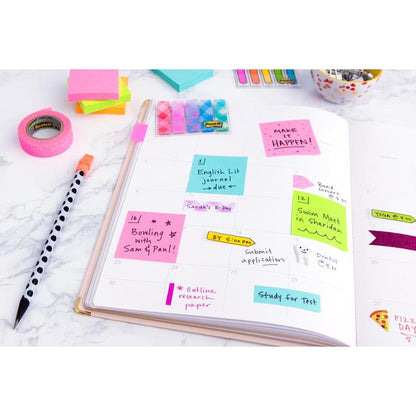 An open planner on a marble surface shows handwritten notes with colorful 3M Deutschland GmbH Post-it® Notes Cube, Ultra Colors (76 mm x 76 mm, 450 sheets, PEFC certified), along with washi tape, a dot pen, and paper clips.