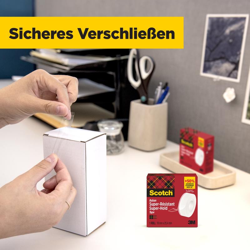 A person seals a white package on the table with Scotch® Super-Hold Secure Tape, 1 roll, 19 mm x 25.4 m from 3M Deutschland GmbH. In the background, office supplies and the packaging of the transparent tape can be seen.