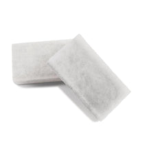 Two rectangular white TASKI AERO exhaust filter pads from Diversey Deutschland GmbH & Co. OHG overlap on a white background and show a fibrous structure - ideal replacement pads for TASKI AERO vacuum systems. Box contains 10 packs.