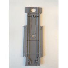 The Dr. Schnell back panel for dispenser Euro bottle by DR.SCHNELL GmbH & Co. KGaA is a rectangular, light gray plastic piece with raised areas, circular holes, and grooves for dispenser attachment, depicted on a white background.