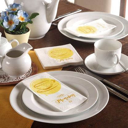 A neatly set table with white dishes, a teapot, blue flowers, and 3-ply PAPSTAR napkins (33 x 33 cm) by PAPSTAR GmbH with a yellow coffee cup and the inscription "Morning".