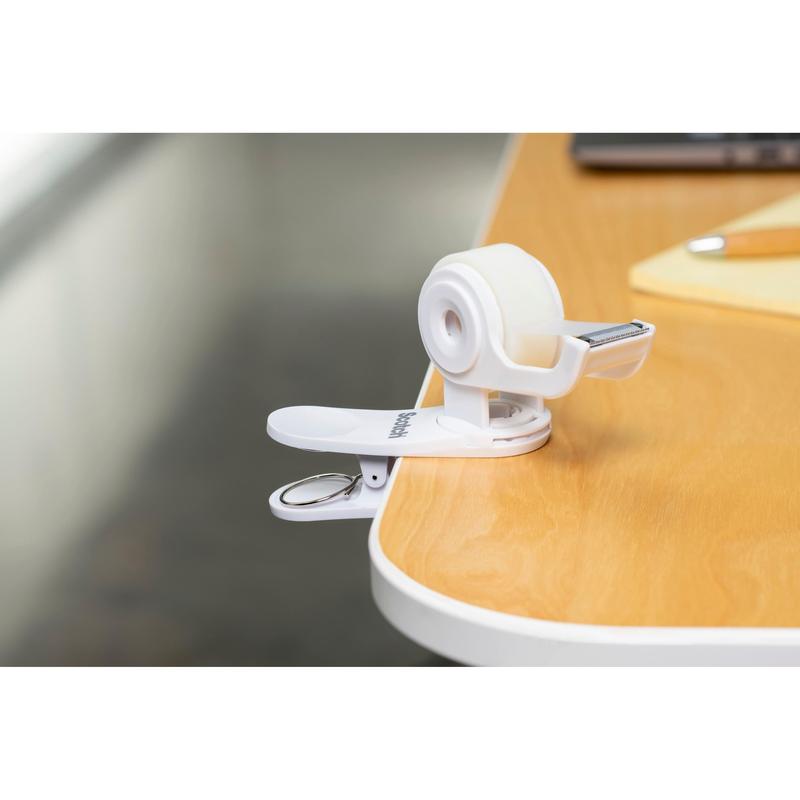 The Scotch™ Clip & Twist Tape Dispenser C19 with Scotch® Magic™ Invisible Tape (19 mm × 8.89 m) from 3M Deutschland GmbH is clipped to a wooden table next to a notepad and a pen.