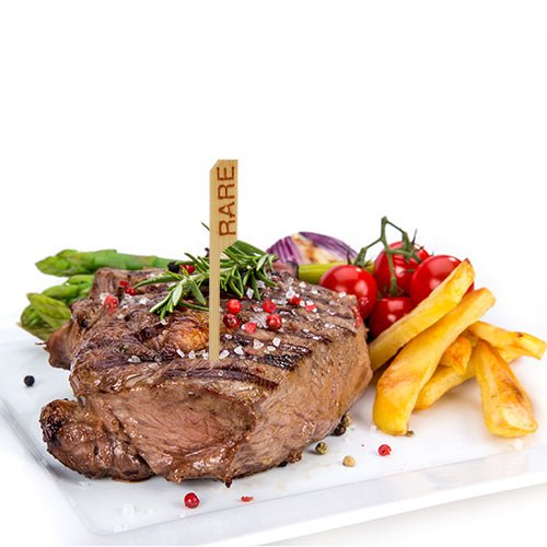 A grilled rare steak marked with the PAPSTAR 250 steak marker (9 cm) from PAPSTAR GmbH, served with French fries, asparagus, vine cherry tomatoes, red onions, and garnished with rosemary and peppercorns – all in restaurant style.