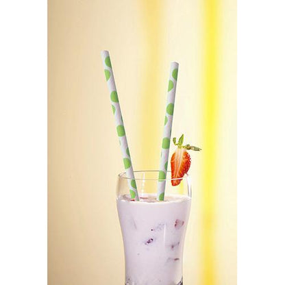 A glass with a creamy white drink and fruit pieces is topped with two PAPSTAR 100 straws, paper Ø 6 mm from PAPSTAR GmbH, with green dots and a strawberry slice on the rim, against a bright yellow background.