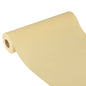 The Starpak table runner, fabric-like, fleece 'Soft Selection Plus' (24 m x 40 cm) in light beige lies partially unrolled on a white background, highlighting its smooth texture and elegant appearance - ideal for special occasions.