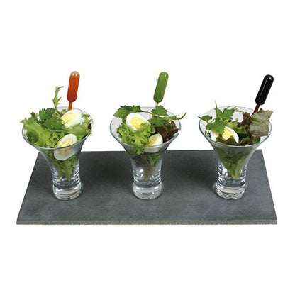 Three glass cups with salad and eggs stand on a slate tray. Each cup contains a Starpak 100 pipette, a transparent PE pipette in orange, green, and black for precise application of the dressing.