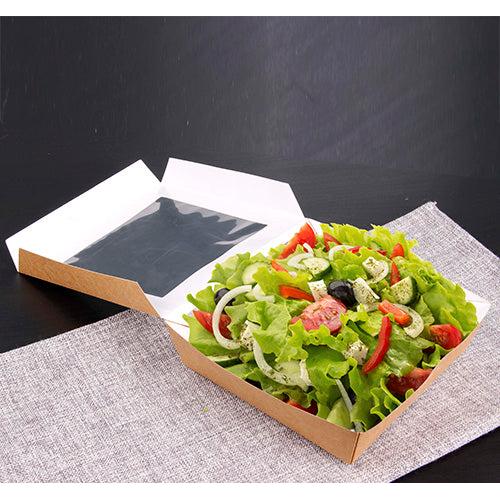 The PAPSTAR 25 gourmet boxes made of cardboard with a PLA window from PAPSTAR GmbH present fresh salad with dressing on a gray, woven placemat on a dark surface – environmentally friendly packaged and stylishly served.