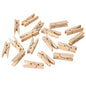A pack of 100 PAPSTAR mini wooden clips (3.5 cm), ideal for craft projects, from PAPSTAR GmbH, is scattered on a white background.
