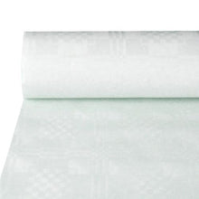 A partially unrolled PAPSTAR paper tablecloth with damask embossing in elegant white lies on the table and shows the subtle, geometric pattern of this festive premium tablecloth from PAPSTAR GmbH.