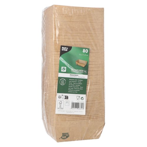 A packaged pack of 80 PAPSTAR snack trays "pure" brown "100% Fair" from PAPSTAR GmbH stands upright, with a label on the front displaying product details and symbols for environmental friendliness and biodegradability; the clear packaging reveals stacked trays inside.