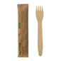 A PAPSTAR wooden fork "pure", 15.5 cm, individually wrapped in shrink film (50 pieces), lies next to its unopened brown packaging from PAPSTAR GmbH with green print and simple design.
