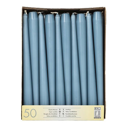 A cardboard box with 50 Starpak taper candles (Ø 2.2 cm - 25 cm), arranged upright in rows, with a label on the front showing the technical data and the long burn time for extended use.