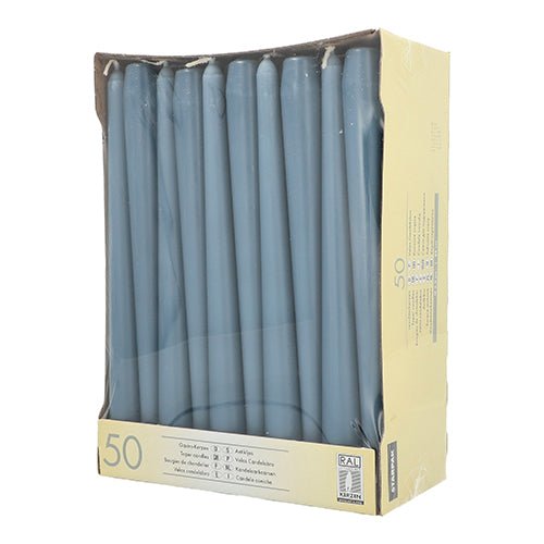 A beige Starpak box contains 50 white taper candles (Ø 2.2 cm - 25 cm) with long burn time. The candles are arranged upright in two rows and visible through a clear window on the front of the packaging.