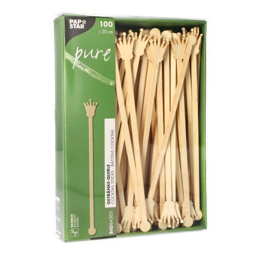 A pack of 100 PAPSTAR 20cm drink stirrers made from biodegradable bamboo, crown-shaped, partially visible through the window. The packaging bears the logo of PAPSTAR GmbH.