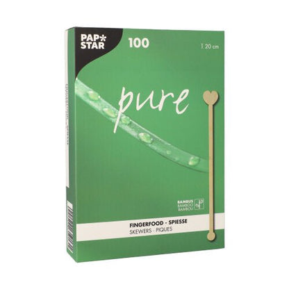 A green box PAPSTAR 100 drink stirrers, bamboo "pure" from PAPSTAR GmbH bears the inscription "100" and "finger food skewers" in white letters. The environmentally friendly, biodegradable design features a bamboo leaf and a heart-shaped skewer image.
