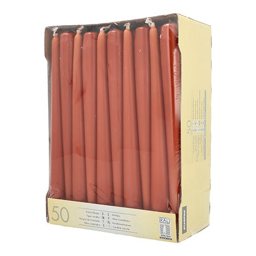 A sealed Starpak box contains 50 taper candles (Ø 2.2 cm, each 25 cm), arranged upright in rows. The rectangular cardboard box has a partially transparent front and top, allowing the candles inside to be visible.