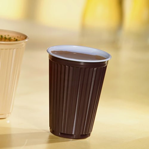 A Starpak 100 thermo vending cup filled with a drink (PS, 0.18 l, Ø 7.03 cm, 9 cm, brown/white) stands on a light surface next to another cup; ideal for drinks on the go. Pack of 100 pieces.