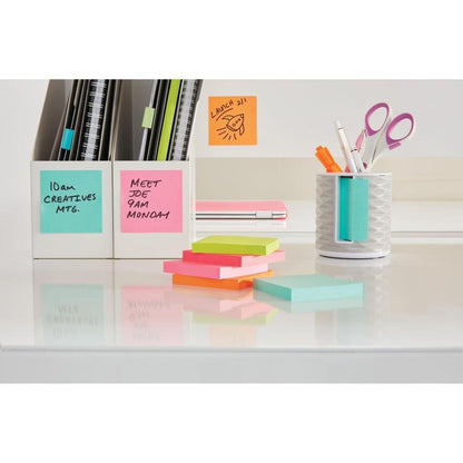 A tidy white desk with 3M Deutschland GmbH Post-it® Notes Cube, Ultra Colors (76 mm x 76 mm, 450 sheets), notebooks, folders in holders, and pastel sticky notes. Reminders and meeting times are displayed on the notes on the desk and wall.