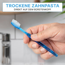 A hand holds an ARNOMED disposable toothbrush with toothpaste from ARNOWA GmbH. German text: "Dry toothpaste directly on the brush head" emphasizes the convenient, quick application on the go. Box contains 100 pieces.