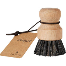 The ENA Living pot brush with soft bristles from Abena Re-Seller GmbH has a round wooden head, a short handle, a leather loop, and a "DISH BRUSH" label - ideal for gentle kitchen cleaning. Available in a box with 12 packs.