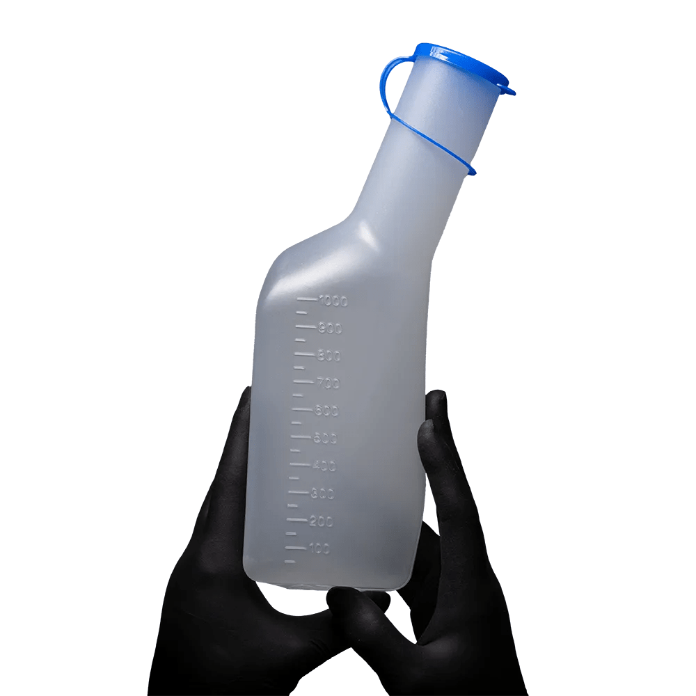 A pair of black-gloved hands holds the AMPri PP urine bottle for men, a rectangular men's urine bottle from AMPri Handelsgesellschaft mbH. The bottle with a blue cap and measuring scale on the side is made of translucent polypropylene and is equipped with an autoclavable, curved neck that stands out against the plain white background.