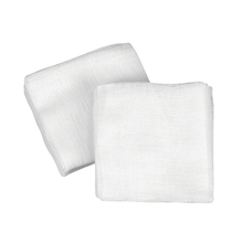 On a white background, there are two unused B. Braun Askina gauze compresses, manufactured by B. Braun Deutschland GmbH & Co. KG, depicted, which are ideal for effective wound care due to their textured and folded surface.