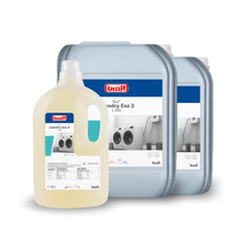 The image shows Buzil's liquid enzyme detergent "Buz® Laundry Enz 3 L 820", designed for professional users. The front container is a compact 2-liter bottle, and the two larger ones are sturdy 20-liter jugs, each featuring a washing machine graphic.