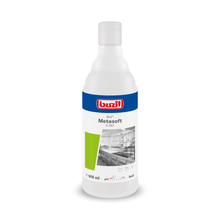 On a 600 ml bottle of Buzil Buz® Metasoft G 507, the logo of BUZIL-WERK Wagner GmbH & Co. KG, the product name, and a kitchen image are clearly visible. The label emphasizes the pH value, the volume, and the effectiveness of the lime dissolving power, all packaged in a green design element.