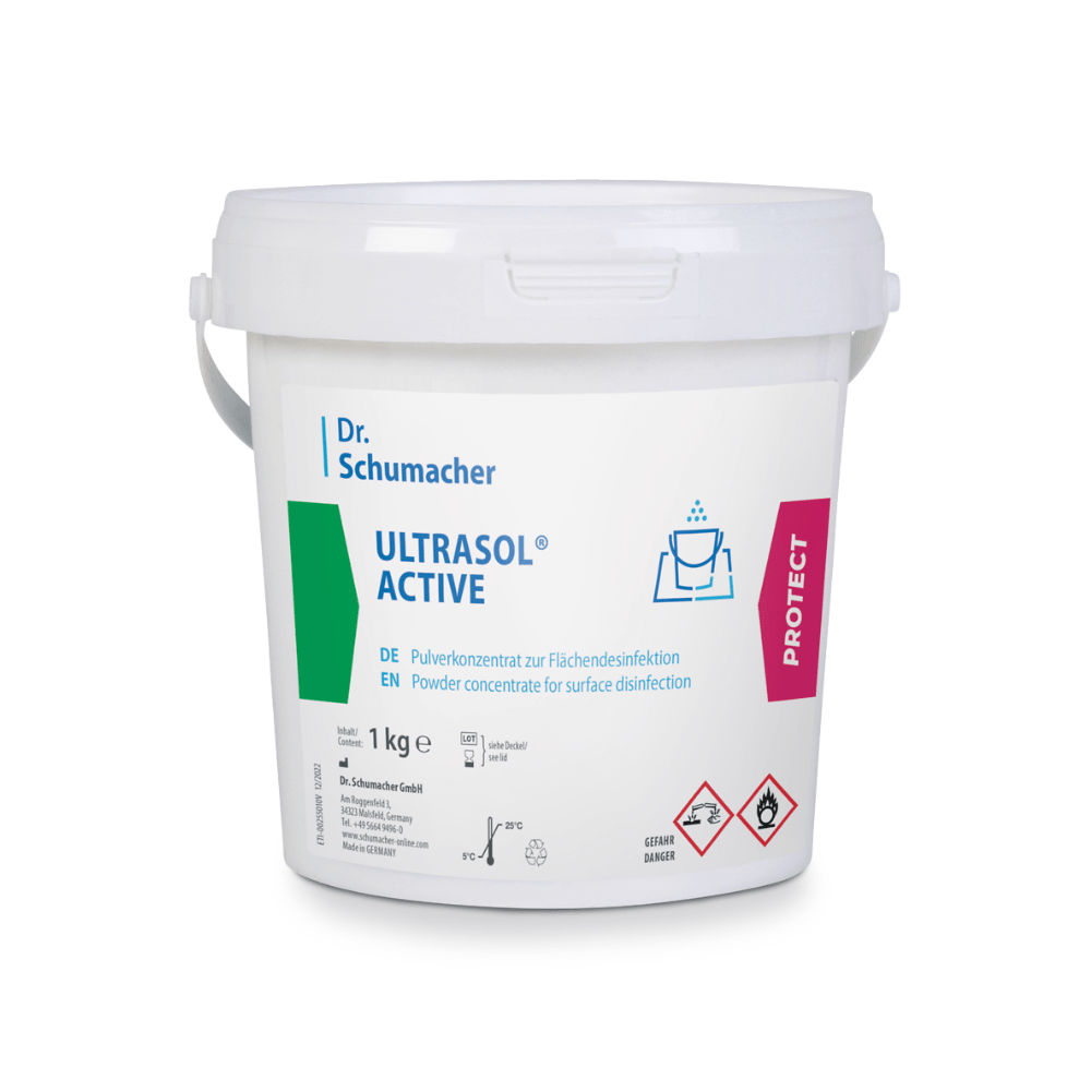 A white plastic container with the label "Dr. Schumacher Ultrasol® Active Surface Disinfection" from Dr. Schumacher GmbH, containing 1 kg of powder concentrate for surface disinfection. The label includes instructions for use in German and English, warning symbols, and a "Protect" symbol on the right side.