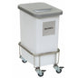A white, rectangular Novocal waste container with the label "RESTMÜLL" and a gray lid is mounted on a Novocal recycling collector chassis with four swivel casters, two of which have brakes.