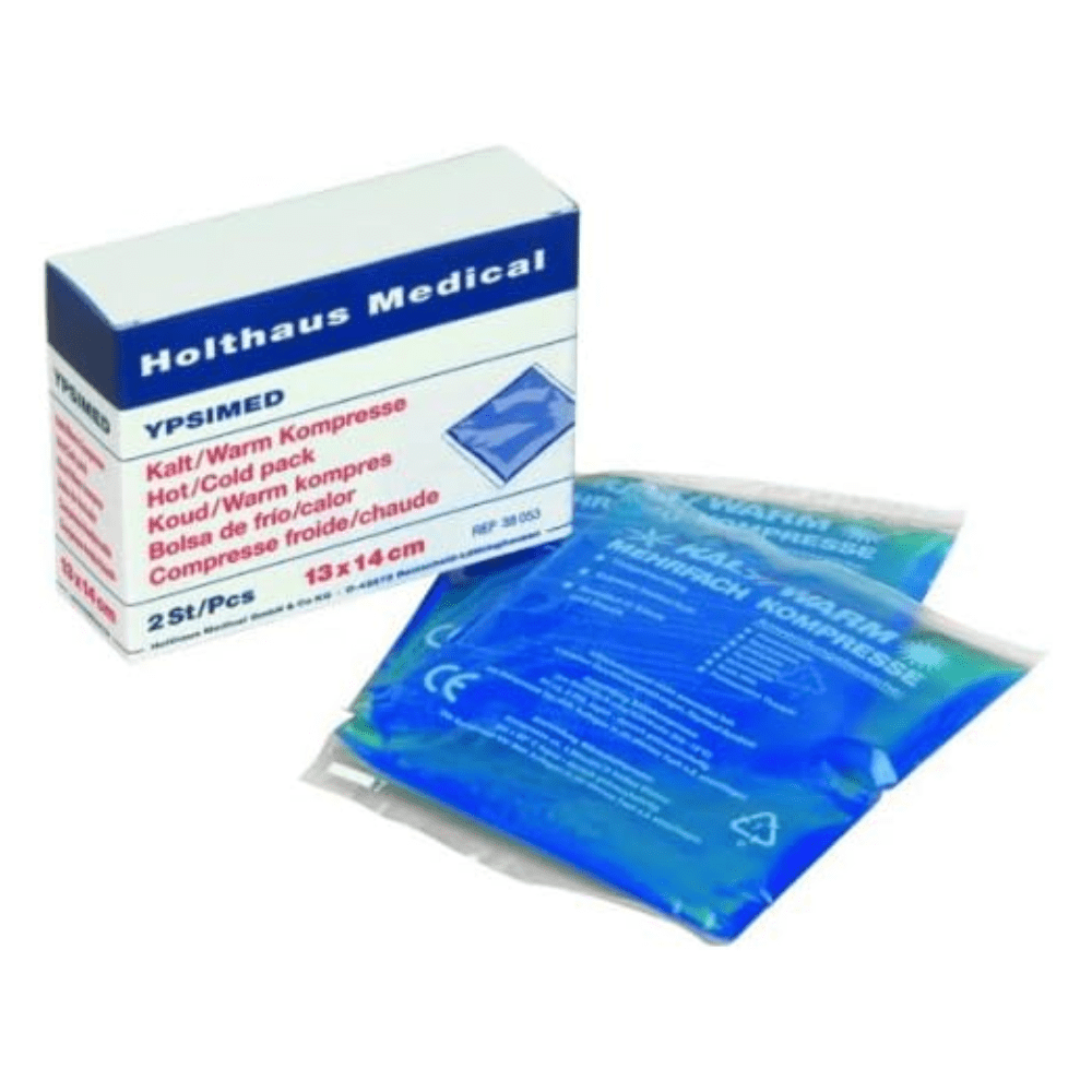 Pictured is a box labeled “Holthaus YPSIMED Cold / Warm Compress 13 x 14 cm | Package (2 pieces)” by Holthaus Medical GmbH & Co. KG. Inside are two compresses, each 13 x 14 cm in size and wrapped in transparent plastic containing a blue liquid. The text on the box is multilingual and emphasizes the hot and cold application of the product, which is essential in first aid situations.