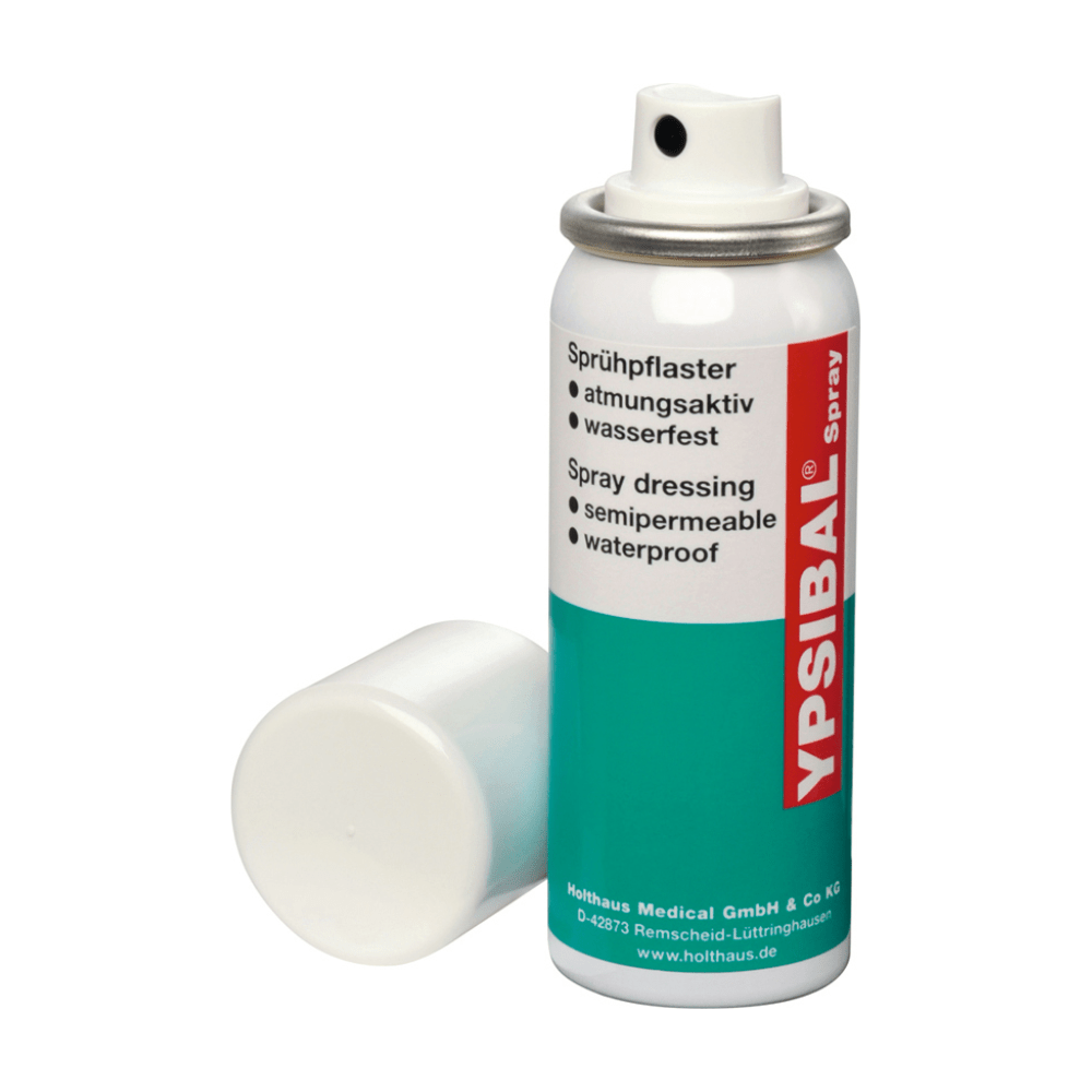 An aerosol can of Holthaus Ypsibal® Spray, spray plaster - 50 ml from Holthaus Medical GmbH & Co. KG is displayed without a white cap and leans on the base. The text on the predominantly white can with blue-green sections and red accents indicates that it is a semi-permeable, waterproof, breathable spray bandage for cuts and abrasions.
