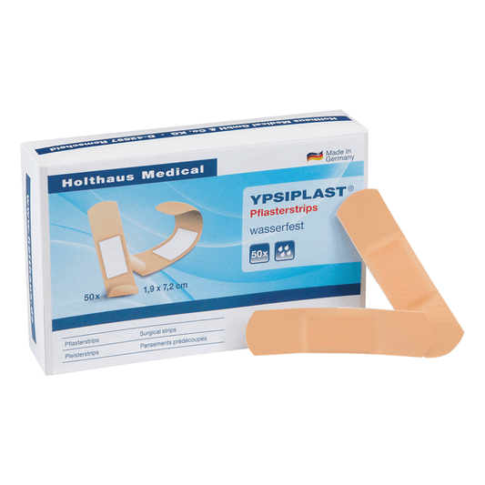 Pictured is a box of Holthaus Ypsiplast® adhesive strips, water-repellent from Holthaus Medical GmbH & Co. KG. The box with the inscription “Made in Germany” shows an image of the strips and states that it contains 50 waterproof adhesive strips measuring 1.9 cm x 7.2 cm. Two strips are also visible outside the box.