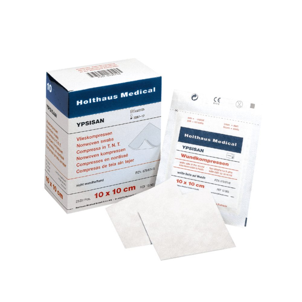 In the picture, there is a box and a package of Holthaus Ypsisan wound compresses, each measuring 10 x 10 cm. The box is open, making the inner packaging visible. In front of the box, there are individual packages and some wound compresses placed, making them ideal for comprehensive wound care. The product is from Holthaus Medical GmbH & Co. KG and includes 50 pieces (25 packages of 2 pieces each).