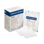 A box of Holthaus Ypsivil cellulose fleece compress, 10 x 10 cm from Holthaus Medical GmbH & Co. KG stands next to a single, unopened package of the same bandage. In front of it lie two unfolded square bandages, whose size and material properties are clearly recognizable.