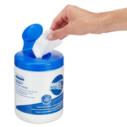 A hand pulls a white Kimtech® Wettask™ DS Wipe from a blue-white canister from Kimberly-Clark GmbH. The flip-top container holds 12 refills x 55 sheets/box, labeled for versatile cleaning wipes and shows product images.