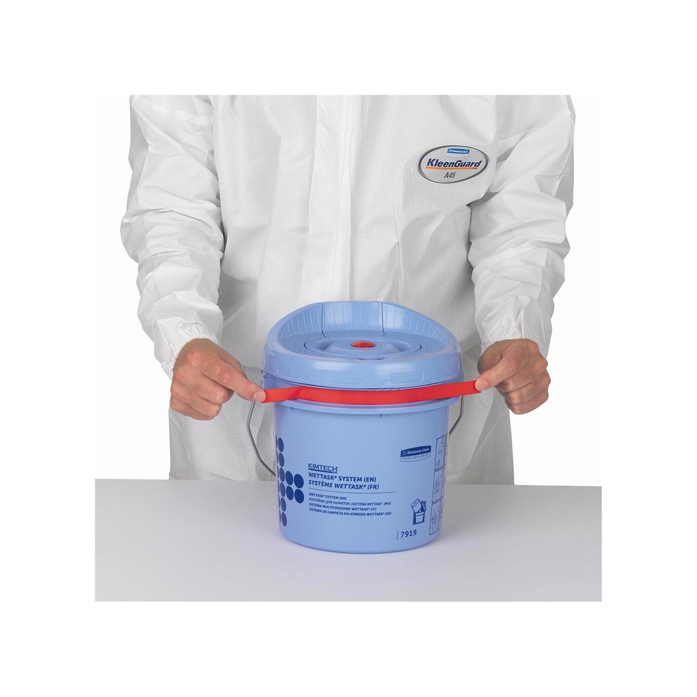 A person in a white KleenGuard suit holds a blue Kimberly-Clark GmbH Kimtech® Wettask™ roll wiper dispenser bucket (cleaning bucket) with a red handle on a white surface.