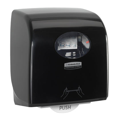 The Aquarius™ Slimroll™ roll towel dispenser in black from Kimberly-Clark GmbH features hygienic towel dispensing, a transparent viewing window, a "PUSH" button on the bottom, and instruction symbols on the front.
